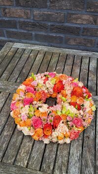 Rouwwerk 113: (Urne) krans oranje/zalm/roze tinten