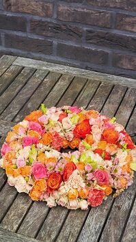 Rouwwerk 113: (Urne) krans oranje/zalm/roze tinten