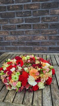 Rouwwerk 116: Bloemrijke (urne) krans in wit/rood/zalm/oranje & roze tinten