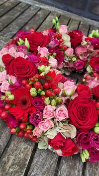 Rouwwerk 144: Bloemrijke (urne)krans rood & roze tinten